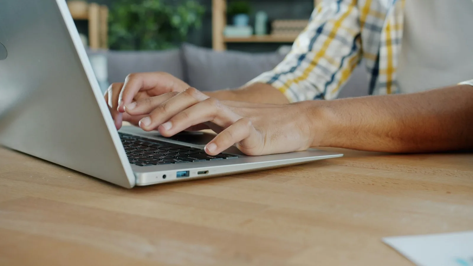 Close-up of hands typing on a laptop keyboard